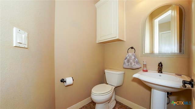 half bath with toilet and baseboards