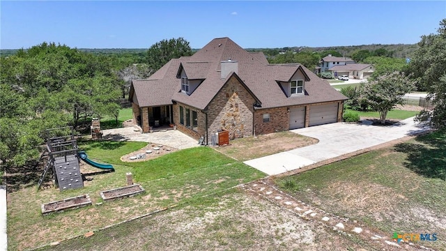 view of front of property with a garage, a front lawn, a playground, driveway, and roof with shingles