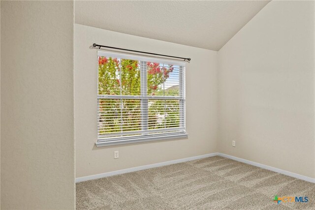 834 Wall St, New Braunfels, TX 78130 - unfurnished room featuring vaulted ceiling, carpet floors, baseboards, and a textured ceiling