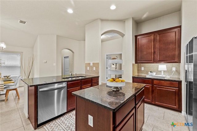 834 Wall St, New Braunfels, TX 78130 - kitchen featuring dishwasher, arched walkways, a sink, tasteful backsplash, and dark stone countertops