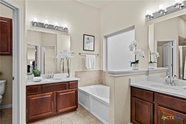 834 Wall St, New Braunfels, TX 78130 - bathroom with a garden tub, two vanities, toilet, tile patterned floors, and a stall shower