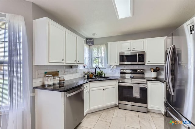 4201 Breckenridge Dr, Killeen, TX 76542 - kitchen with appliances with stainless steel finishes, dark countertops, tasteful backsplash, and white cabinetry