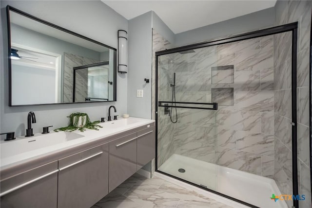 full bath featuring double vanity, marble finish floor, a shower stall, and a sink