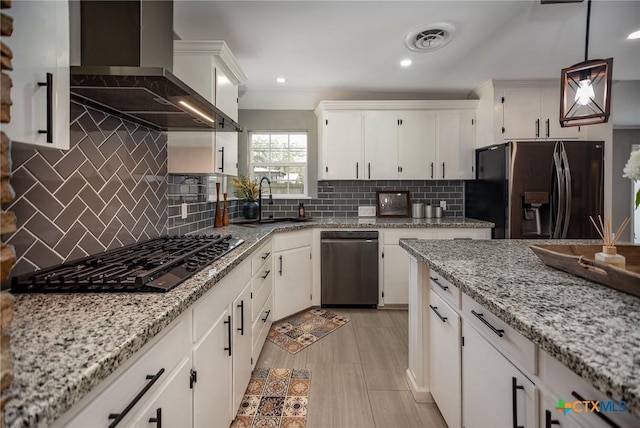 kitchen with visible vents, white cabinets, a sink, wall chimney range hood, and black appliances