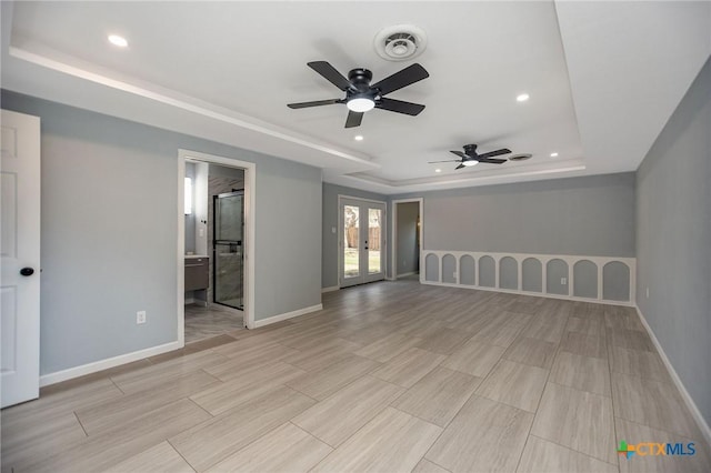 unfurnished room featuring french doors, a raised ceiling, visible vents, and baseboards