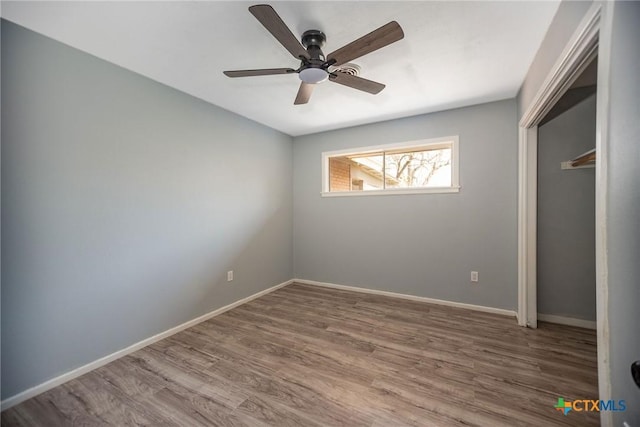 unfurnished bedroom with a closet, wood finished floors, and baseboards