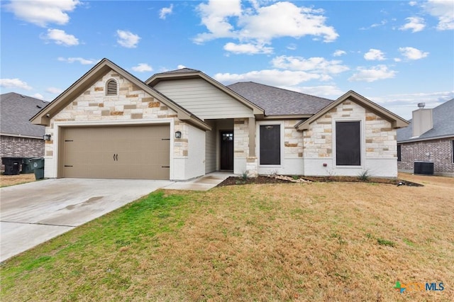 view of front of property with a garage, a shingled roof, concrete driveway, central AC, and a front yard