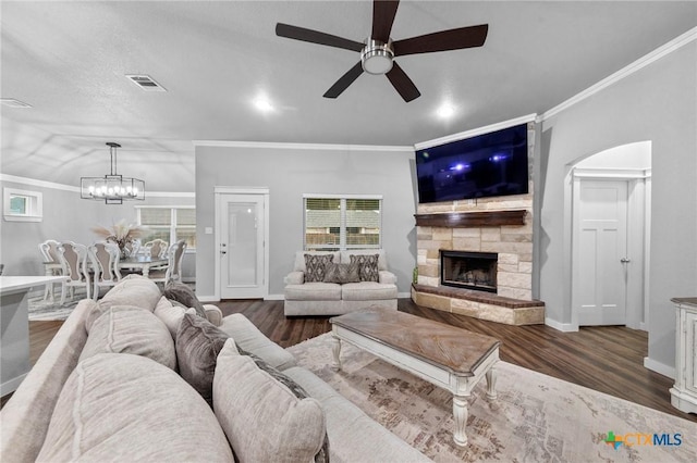 living room with dark wood-style floors, a stone fireplace, baseboards, and crown molding