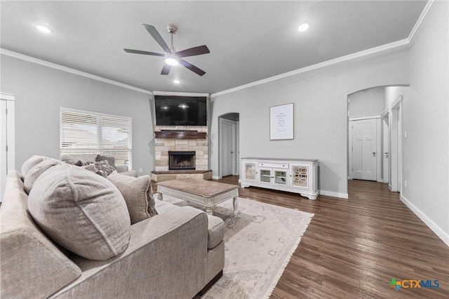 living area featuring ceiling fan, arched walkways, and ornamental molding