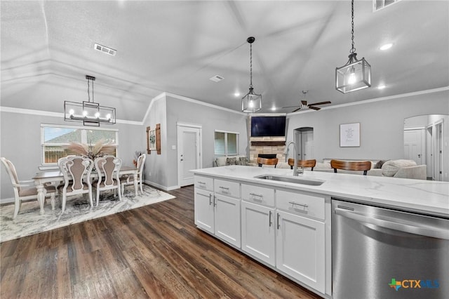 kitchen with arched walkways, a sink, white cabinetry, open floor plan, and dishwasher