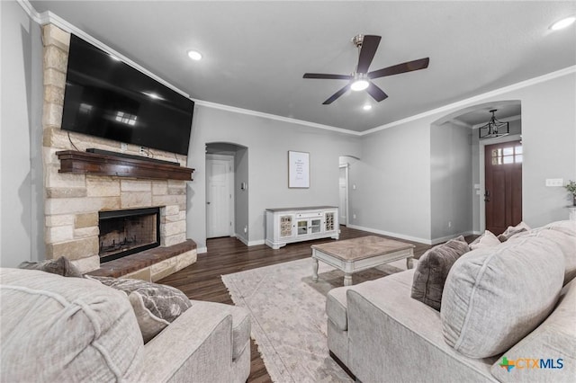 living room with a ceiling fan, arched walkways, and ornamental molding