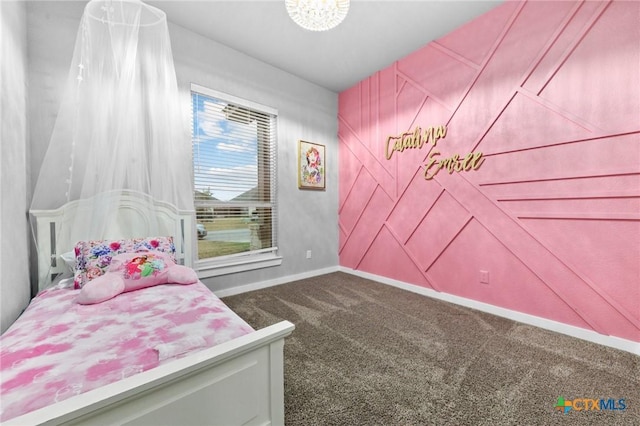 carpeted bedroom featuring an inviting chandelier and baseboards