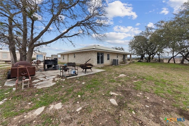 view of yard featuring a fire pit, central AC unit, and a patio area