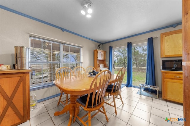 dining area featuring ornamental molding and light tile patterned floors