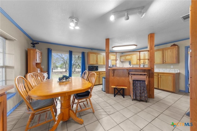 dining space with visible vents, a textured ceiling, and light tile patterned floors