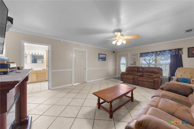 living room with a ceiling fan, crown molding, light tile patterned floors, baseboards, and visible vents
