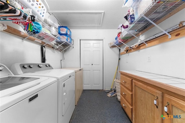 washroom with attic access, washer and dryer, cabinet space, and dark carpet