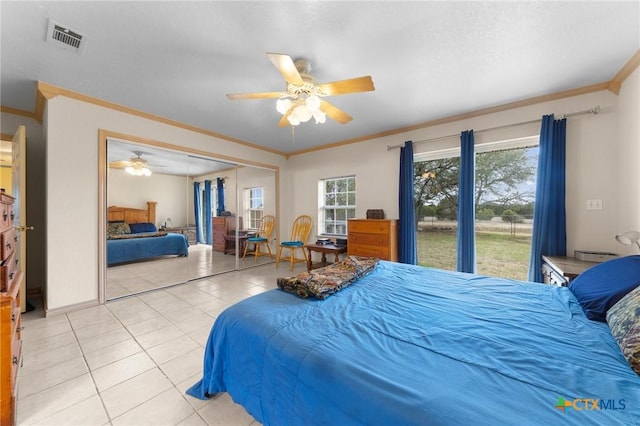 bedroom with visible vents, a ceiling fan, a closet, crown molding, and light tile patterned floors