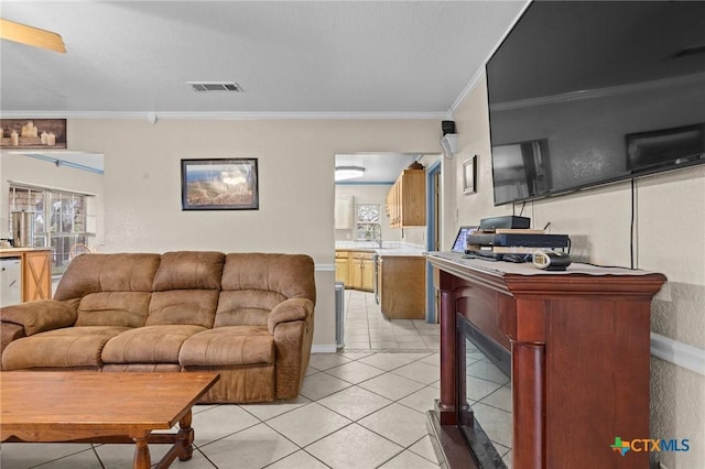 living area featuring ornamental molding, visible vents, and light tile patterned floors