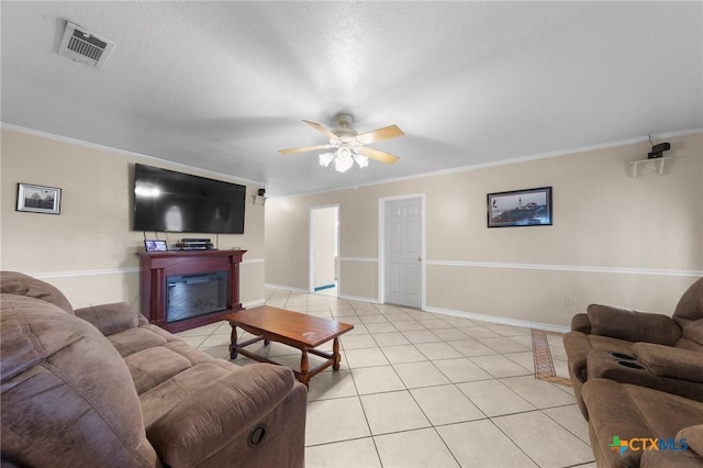 living room featuring ornamental molding, a ceiling fan, visible vents, and light tile patterned floors