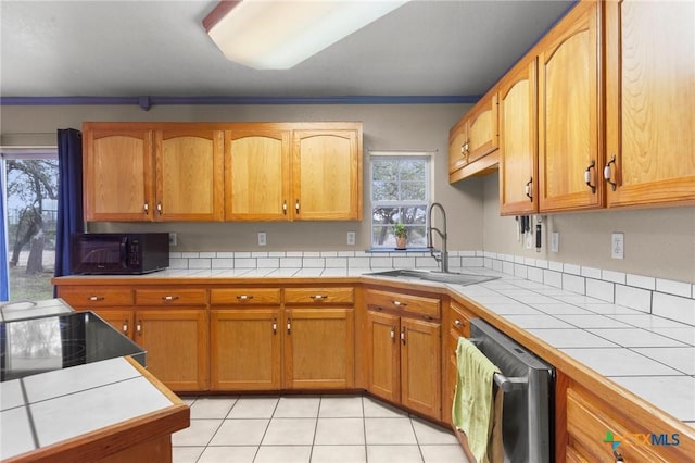 kitchen featuring tile counters, dishwasher, light tile patterned floors, a sink, and black microwave