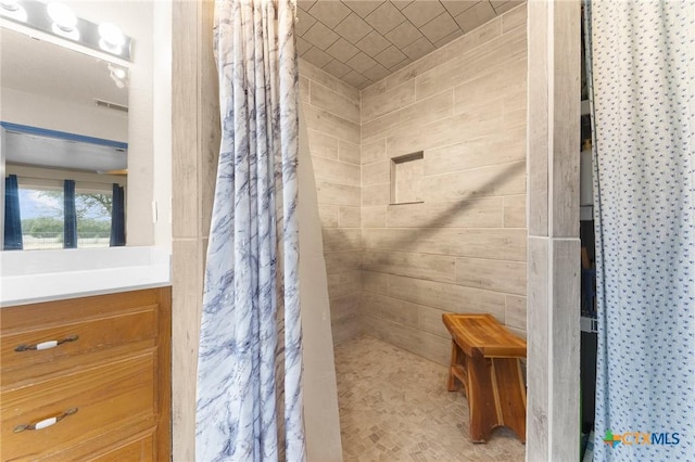 full bathroom with vanity and tiled shower