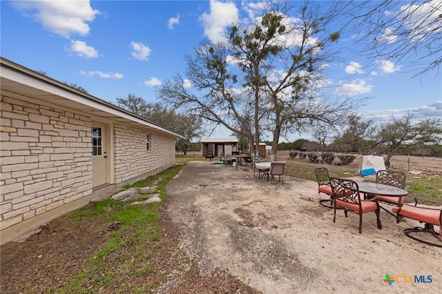 view of yard with fence and outdoor dining area