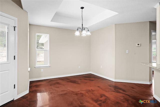 interior space featuring a tray ceiling and a chandelier