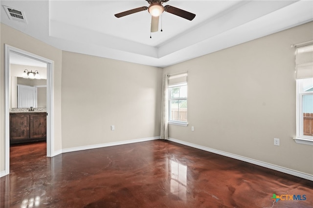 unfurnished room with sink, a raised ceiling, and ceiling fan