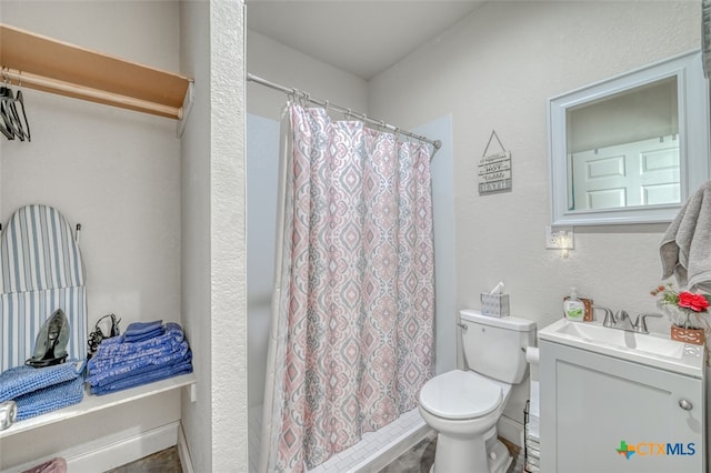 bathroom featuring toilet, vanity, and a shower with shower curtain