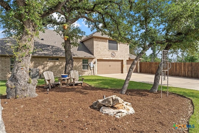 6 Salta Ct, Belton, TX 76513 - rear view of house with a garage, fence, driveway, brick siding, and roof with shingles