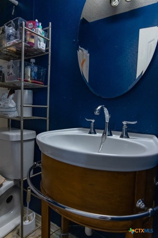 bathroom featuring vanity, toilet, and a textured ceiling