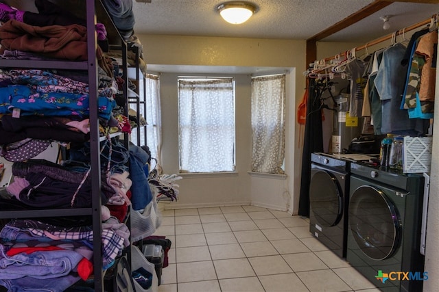 interior space with washer and dryer, a textured ceiling, and light tile patterned floors