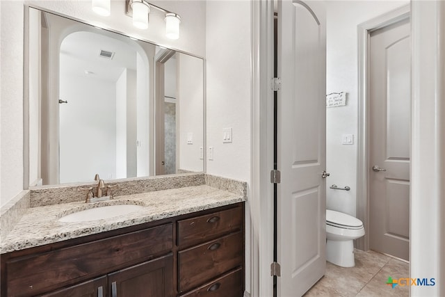 bathroom featuring tile patterned flooring, vanity, and toilet