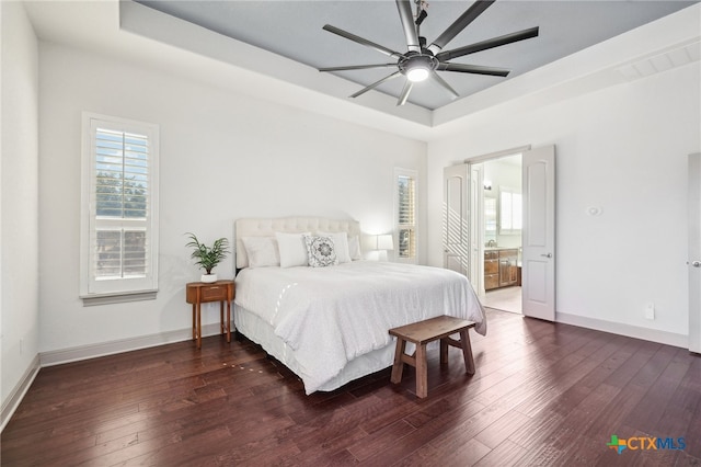 bedroom with ceiling fan, dark hardwood / wood-style flooring, multiple windows, and ensuite bath