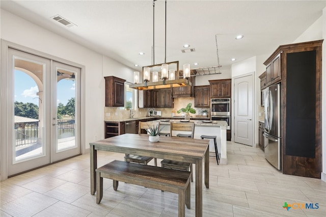 dining space with sink and french doors