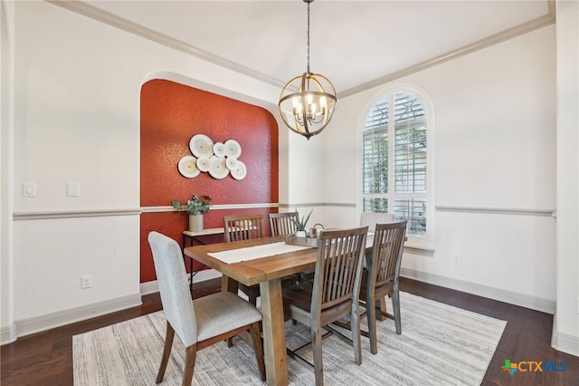 dining room featuring dark hardwood / wood-style floors, crown molding, and a chandelier