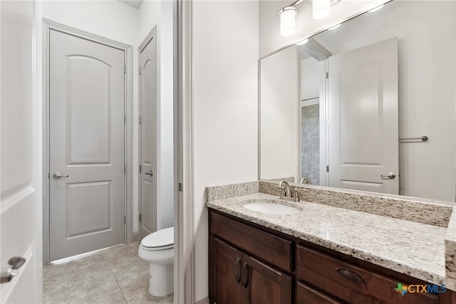 bathroom featuring tile patterned flooring, vanity, and toilet