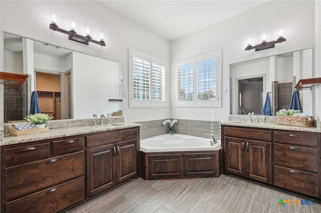 bathroom with a washtub and vanity