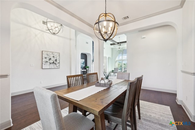 dining space featuring ceiling fan with notable chandelier, dark hardwood / wood-style flooring, and crown molding