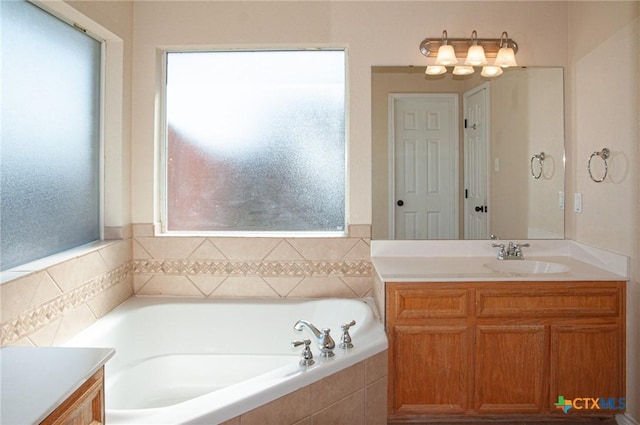 bathroom with vanity and tiled tub