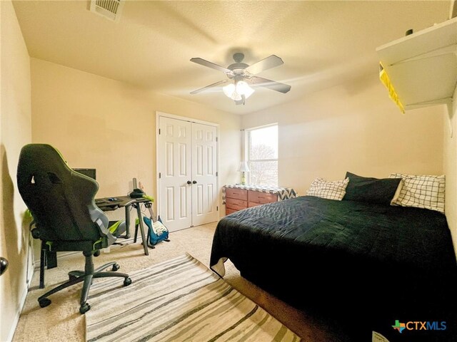 carpeted bedroom featuring ceiling fan, crown molding, and a raised ceiling