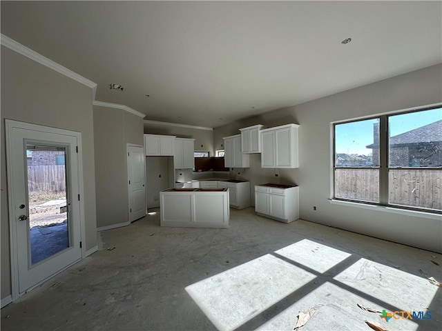 kitchen featuring ornamental molding, a kitchen island, and white cabinets