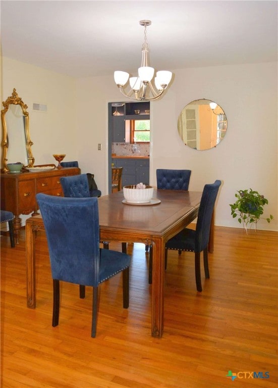 dining room with an inviting chandelier and light hardwood / wood-style floors