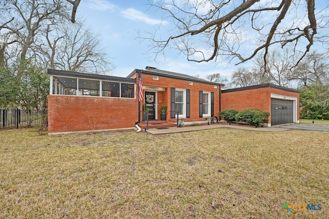 modern home featuring a garage, a sunroom, and a front lawn