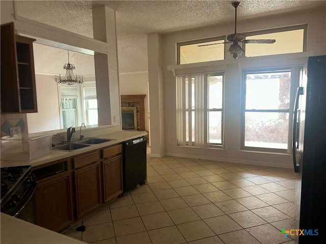 307 Illinois Dr, Harker Heights, TX 76548 - kitchen featuring black appliances, a sink, a textured ceiling, healthy amount of natural light, and light tile patterned flooring