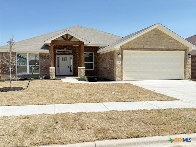 view of front of property with a garage, brick siding, and concrete driveway