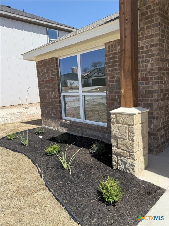 view of side of home featuring board and batten siding and brick siding