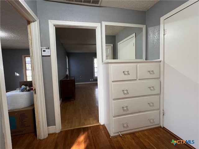 1215 S 47th St, Temple, TX 76504 - corridor featuring dark wood-style flooring and a textured ceiling