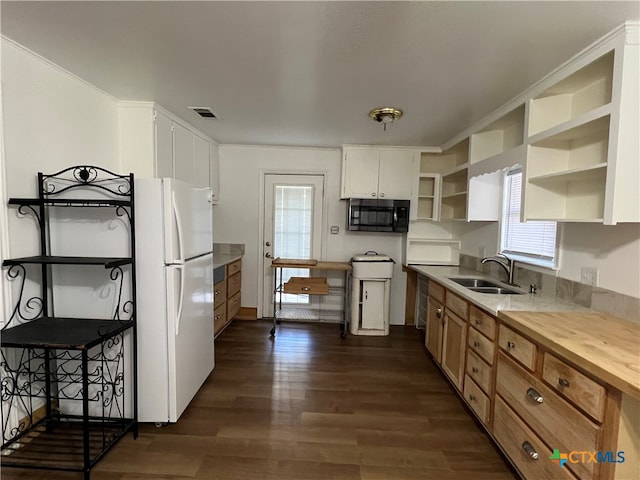 kitchen featuring dark wood-type flooring, white cabinets, crown molding, sink, and white fridge